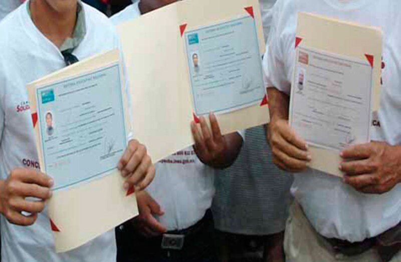 Jóvenes mostrando sus certificados de vacunación.