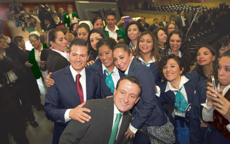 El Presidente Enrique Peña Nieto se toma una foto con un grupo de enfermeras.