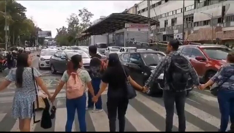 Mujeres tomadas de la mano en un paso de peatones