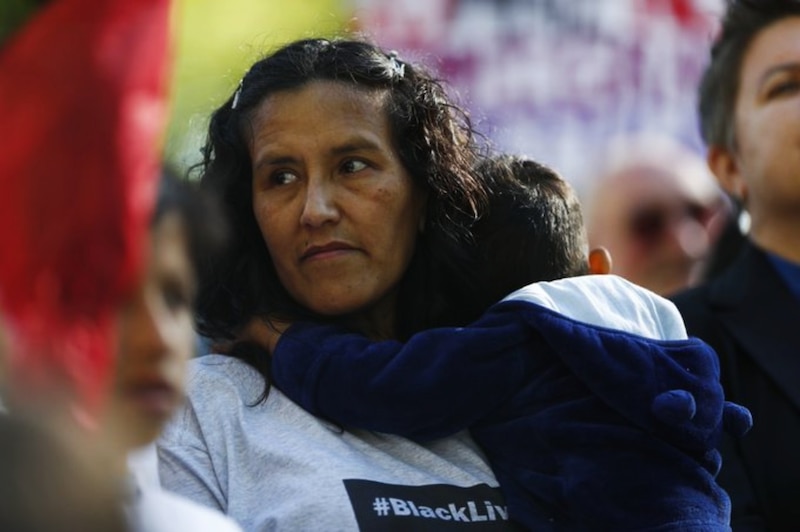 Foto de la activista Jeanette Vizguerra cargando a uno de sus hijos