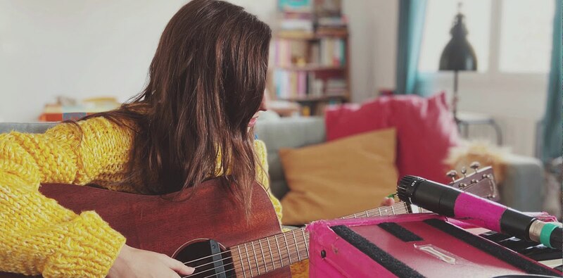 Mujer tocando la guitarra en casa