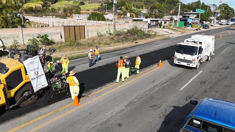Cuadrilla de trabajadores arreglando baches sobre una carretera federal como parte del programa Bachetón