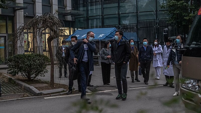 Un grupo de personas con mascarillas caminan por una calle en China