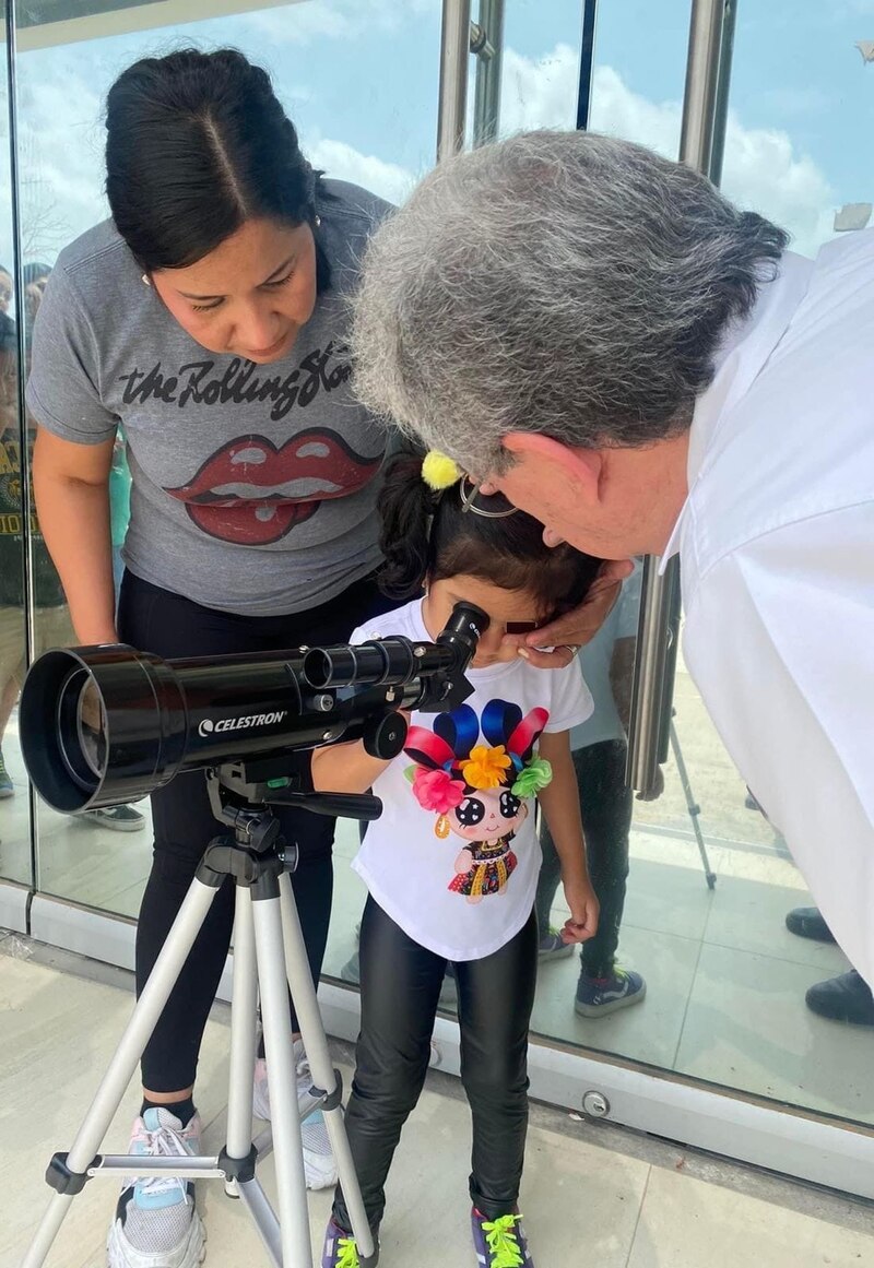 Una niña mira a través de un telescopio