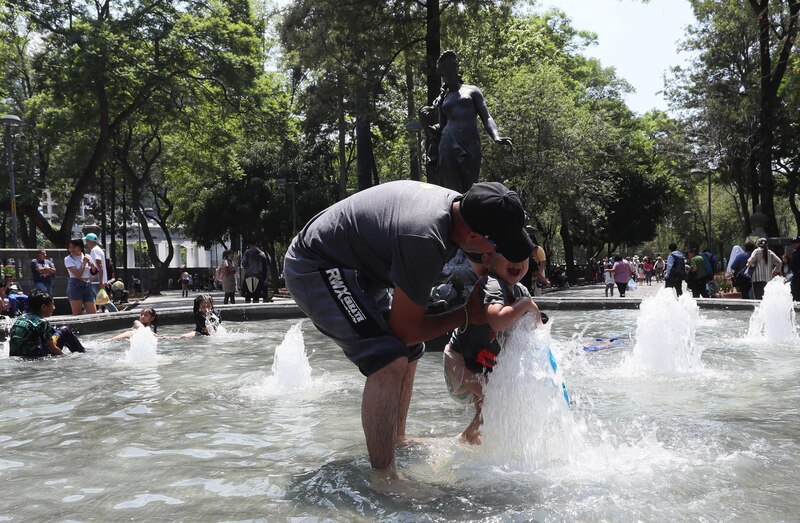 Padre e hijo se divierten en una fuente