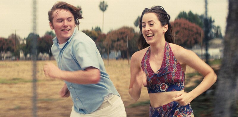 Una pareja joven corre por un campo