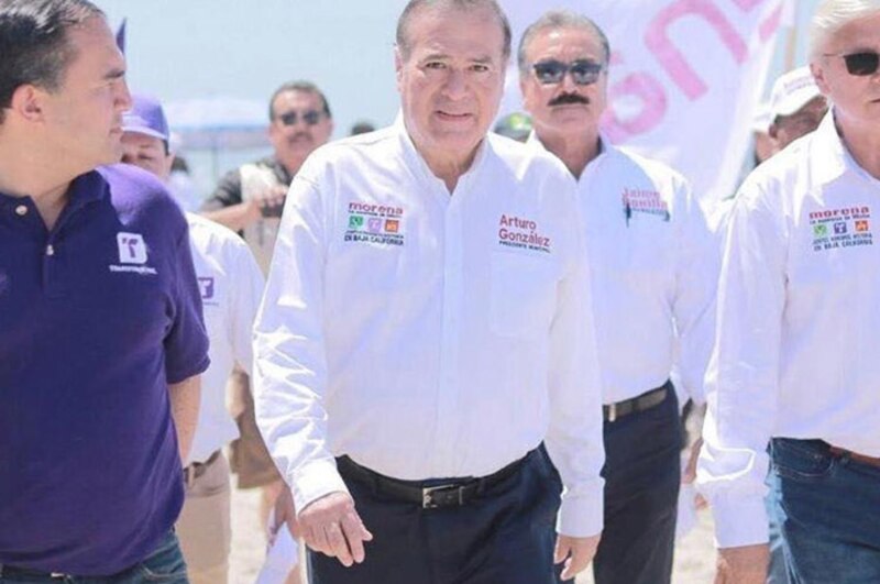 El candidato Arturo González camina por la playa con sus simpatizantes