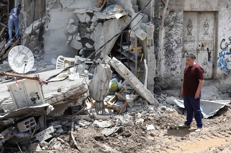 Un hombre inspecciona los daños en su casa después de un ataque aéreo en Gaza