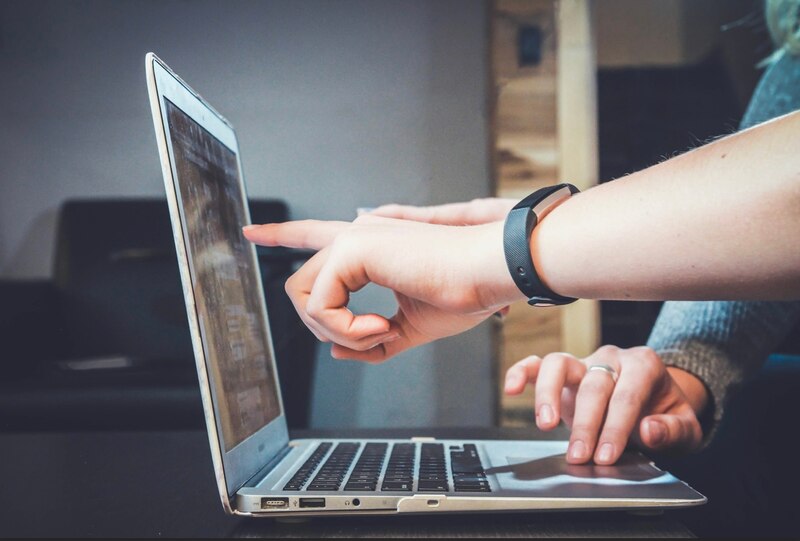 Dos personas trabajando juntas en una computadora portátil