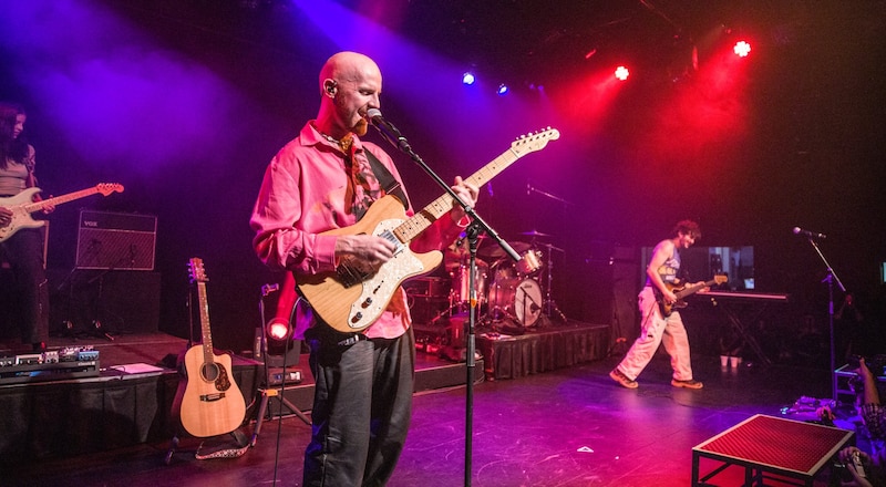 Artista tocando la guitarra en un concierto