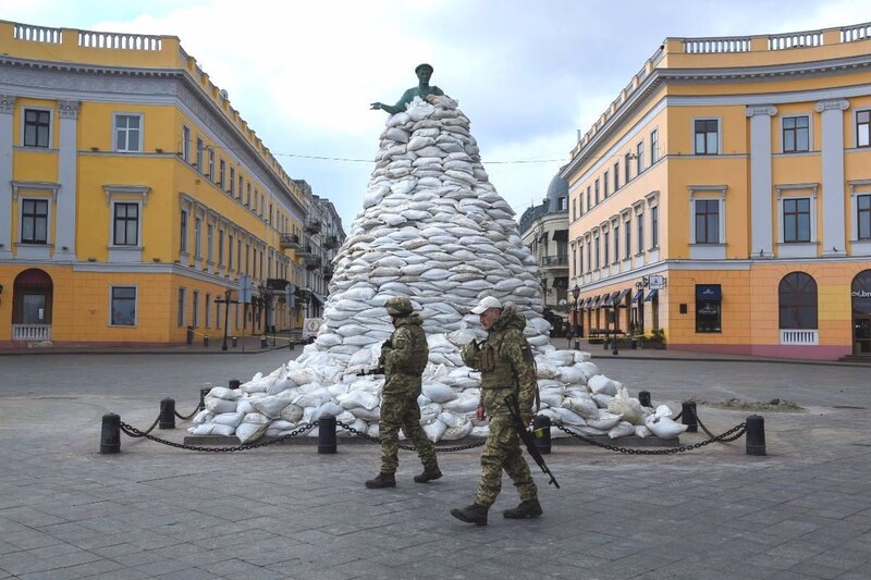 Soldados ucranianos custodian un monumento protegido con sacos terreros en la ciudad de Járkov