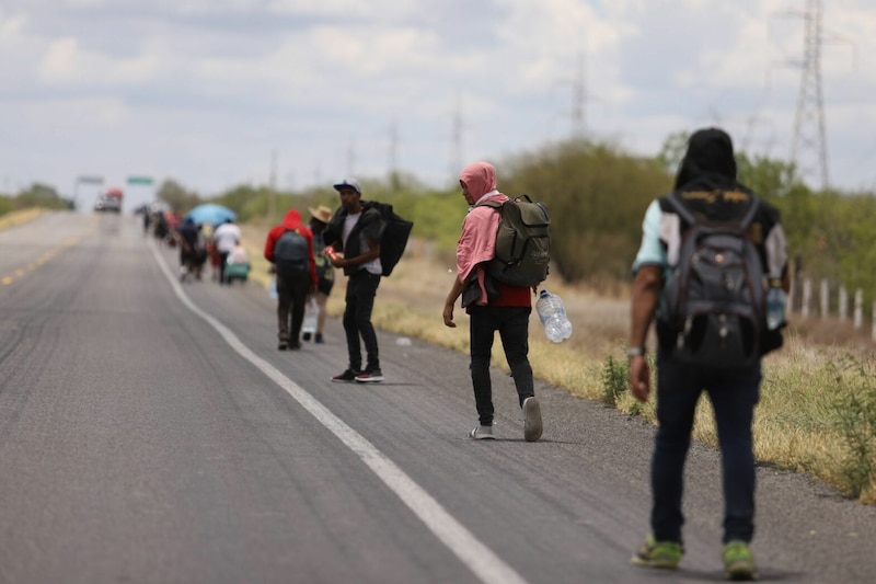 Migrantes caminan por una carretera en busca de una nueva vida