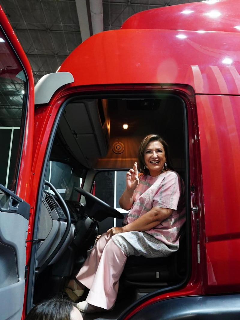 Mujer sentada en el asiento del conductor de un camión rojo