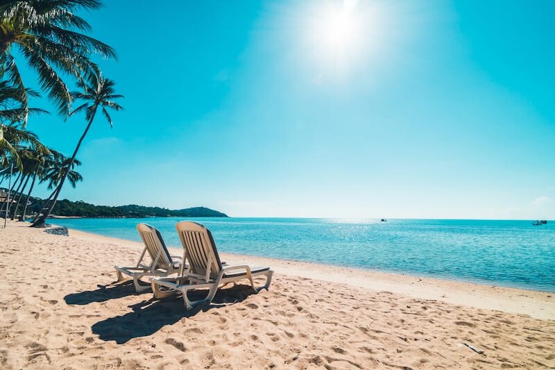 Playa tropical con dos sillas vacías