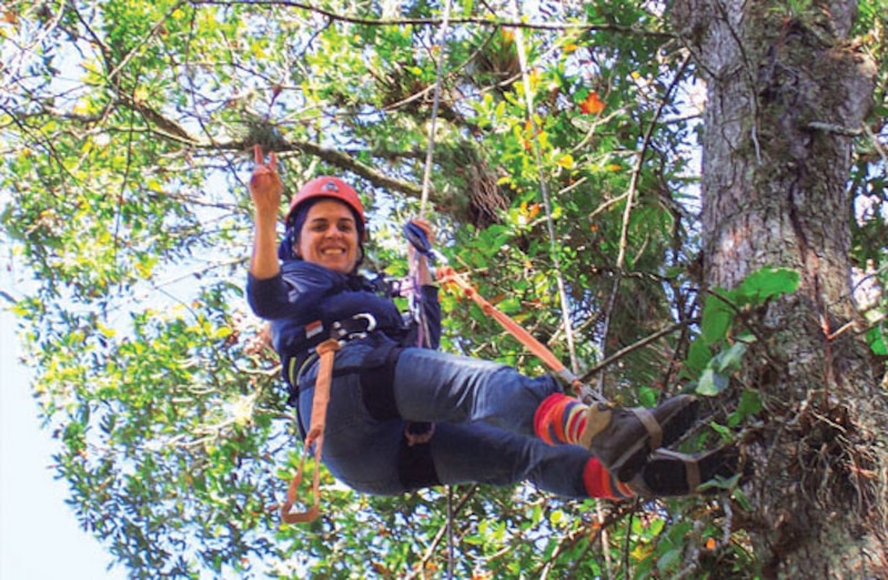 Mujer haciendo rappel en un árbol