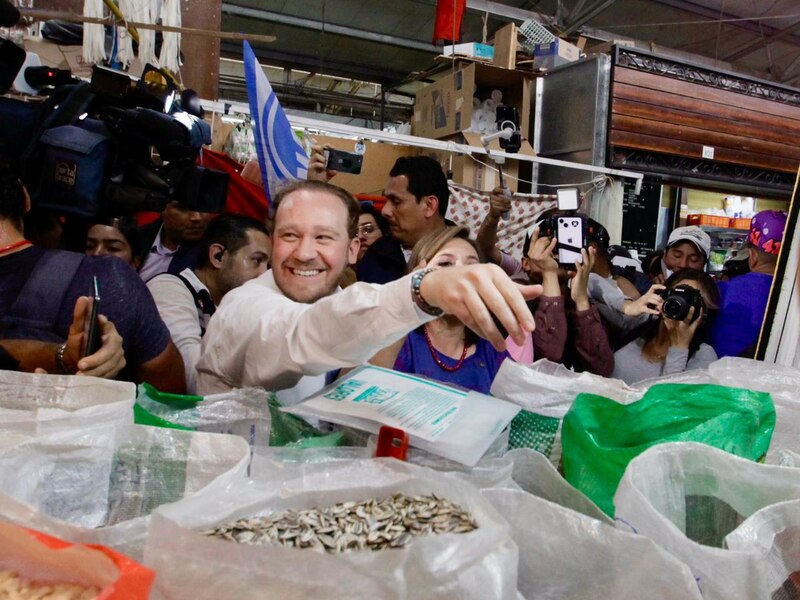 El candidato presidencial López Obrador saluda a sus seguidores en un mercado de la Ciudad de México.