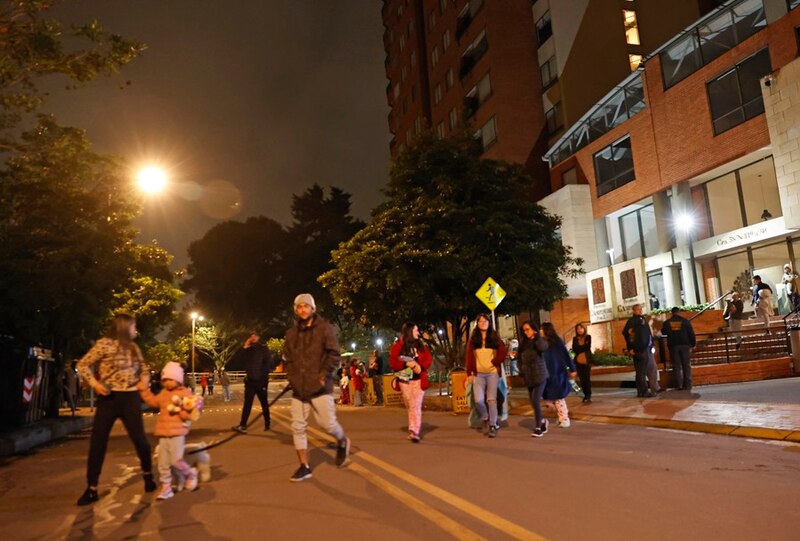 Un grupo de personas camina por una calle oscura