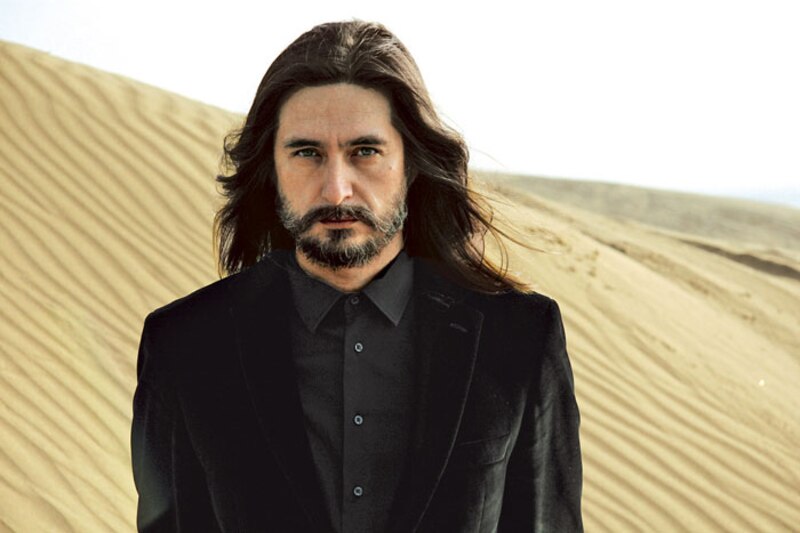 Un hombre con barba y pelo largo en el desierto