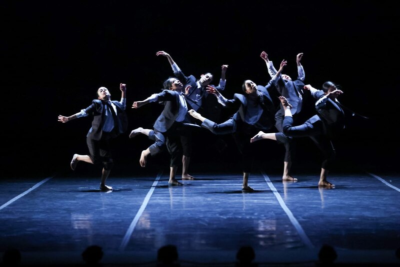 Una compañía de danza contemporánea realiza una coreografía en un escenario.