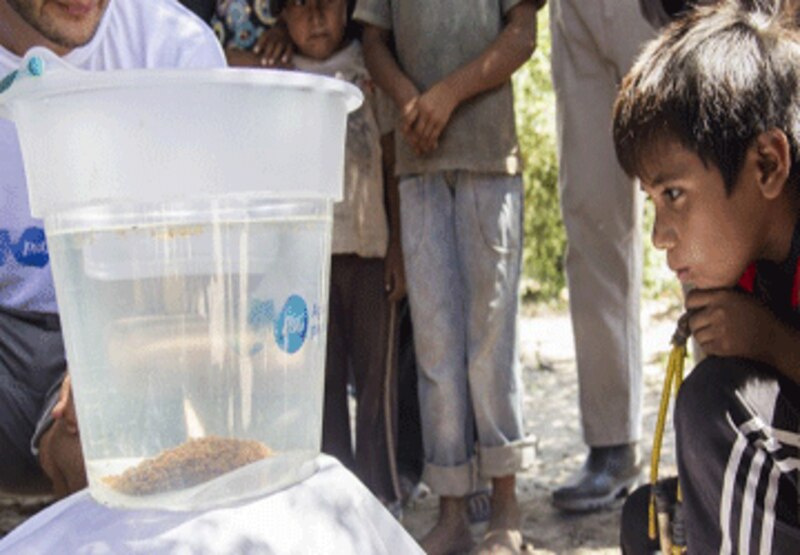 Niño hondureño observa cómo se purifica el agua