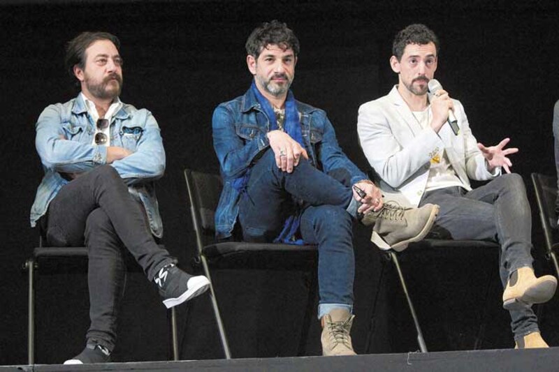 Tres hombres en un panel de discusión