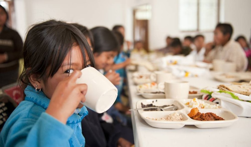 Niña desayunando en un comedor social