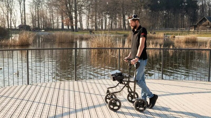 Hombre joven en silla de ruedas eléctrica en un parque