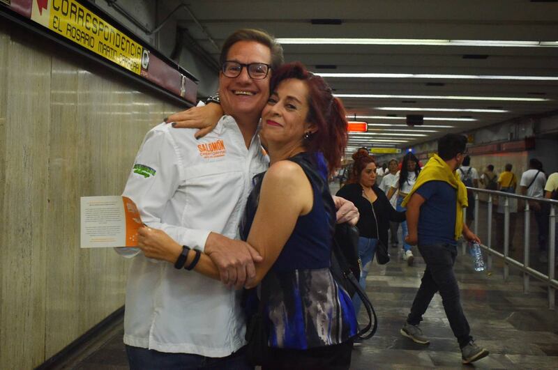Dos mujeres se abrazan en una estación de metro.