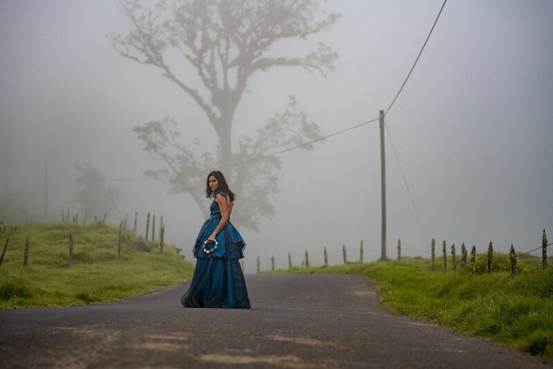Mujer de pie en la carretera con un vestido azul.