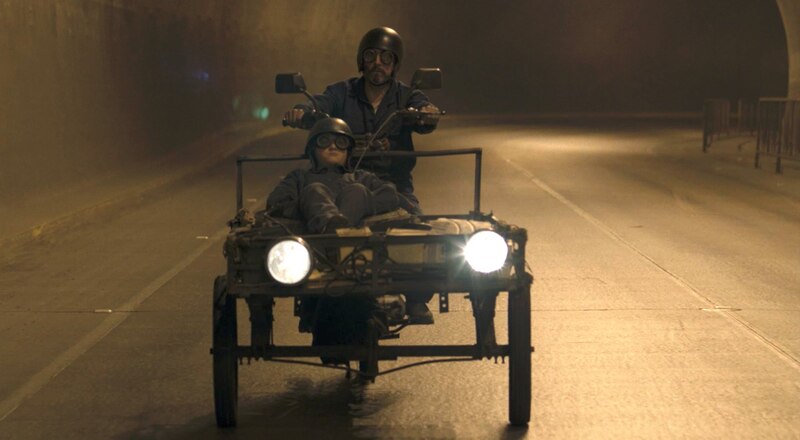 Dos hombres en una motocicleta con sidecar conduciendo por un túnel.
