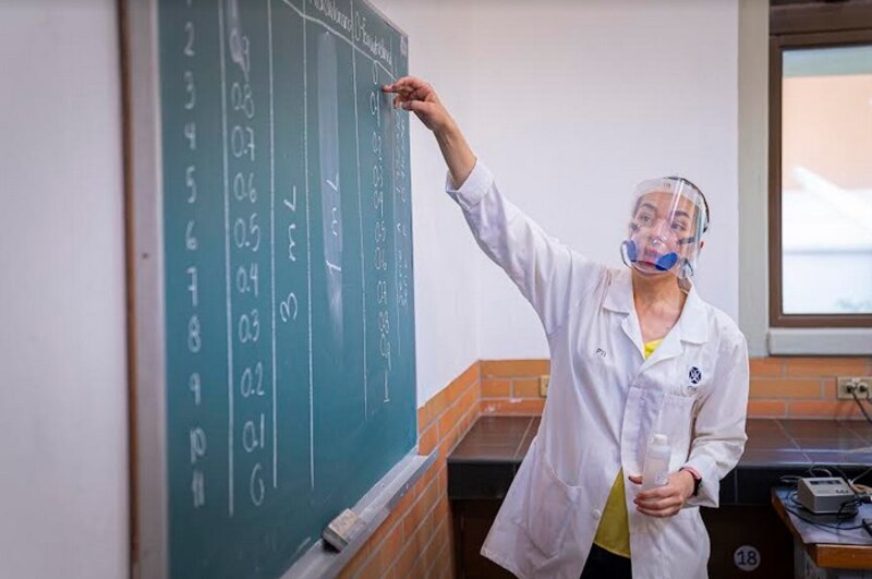 Profesora dando clase en la pizarra