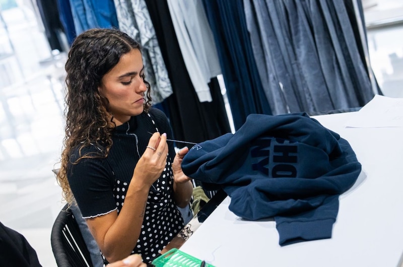 Una mujer cosiendo una prenda