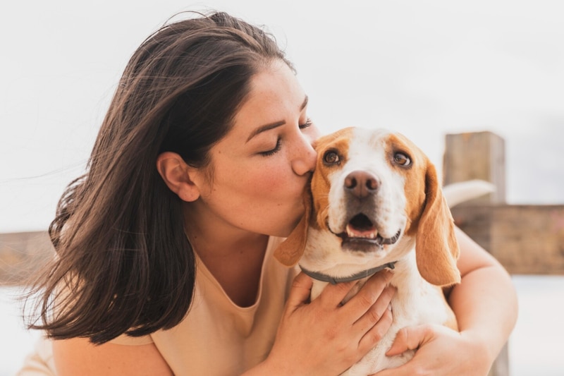 Mujer besando a un perro