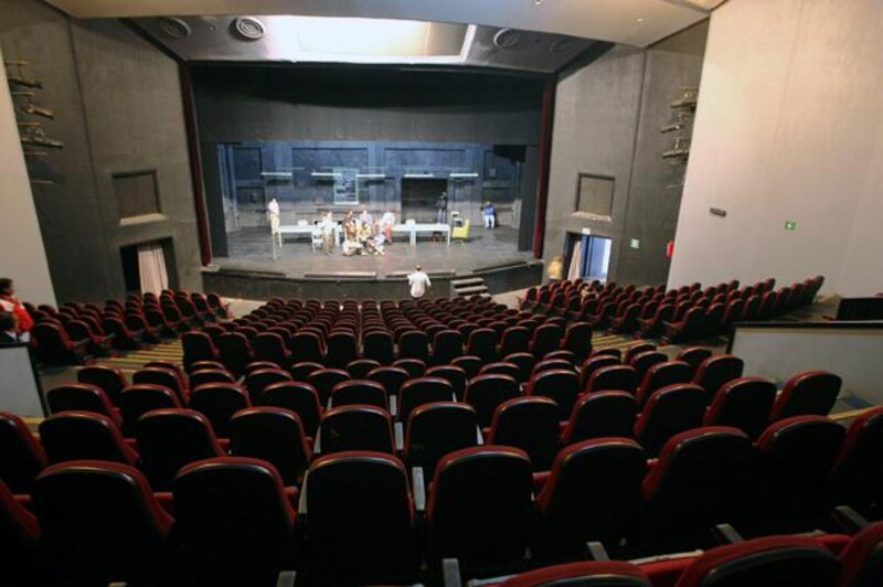 Un teatro vacío con butacas rojas