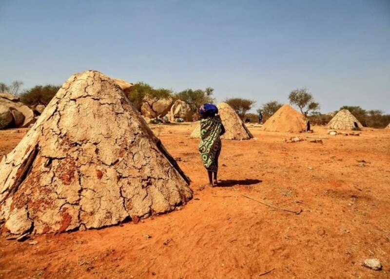 Mujer caminando en una aldea africana