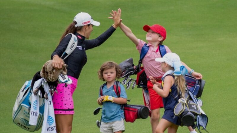 La golfista profesional Stacy Lewis choca los cinco con un joven fanático después de la ronda final del torneo.