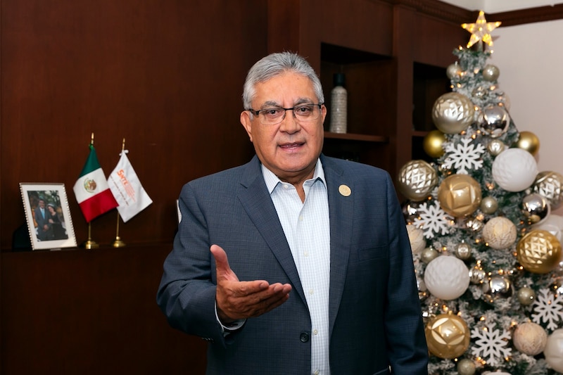 El presidente Andrés Manuel López Obrador da un discurso frente a un árbol de Navidad.