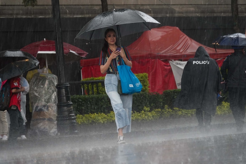 Mujer camina bajo la lluvia en la Ciudad de México