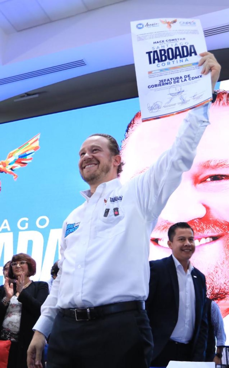 "El político sostiene una pancarta con su nombre y sonríe a la cámara"