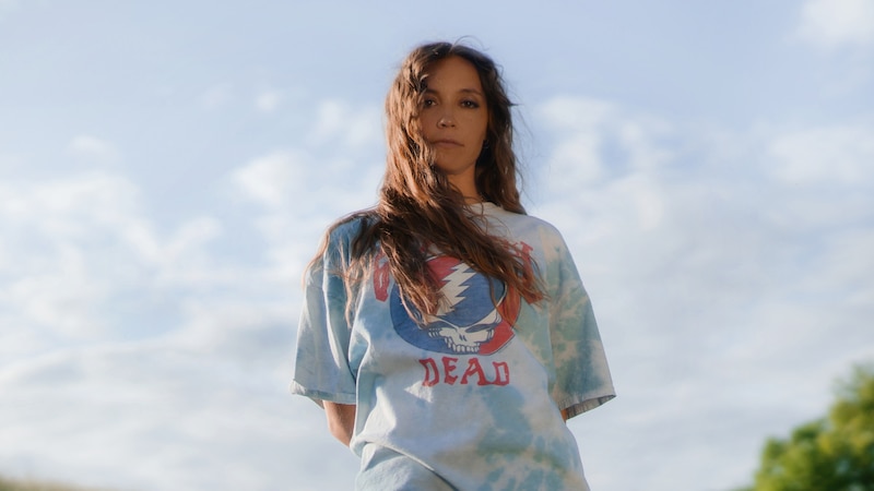 Mujer joven con una camiseta tie-dye de Grateful Dead