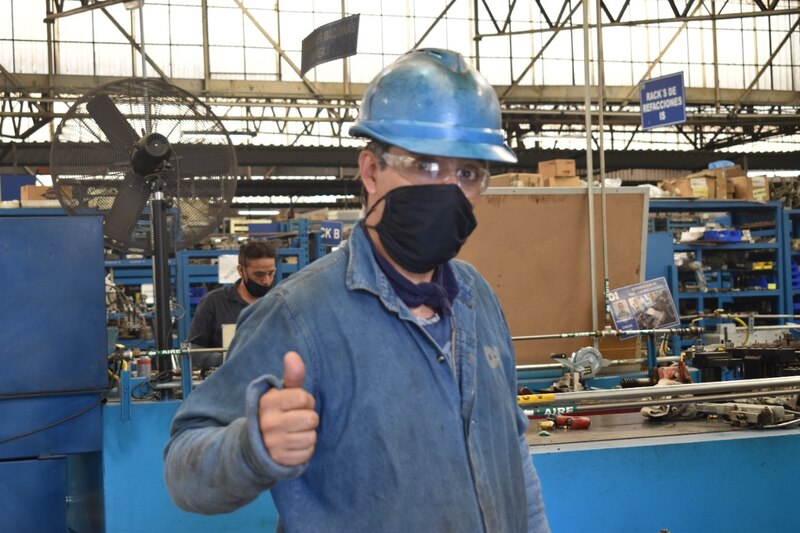 Un trabajador de una fábrica muestra un pulgar hacia arriba