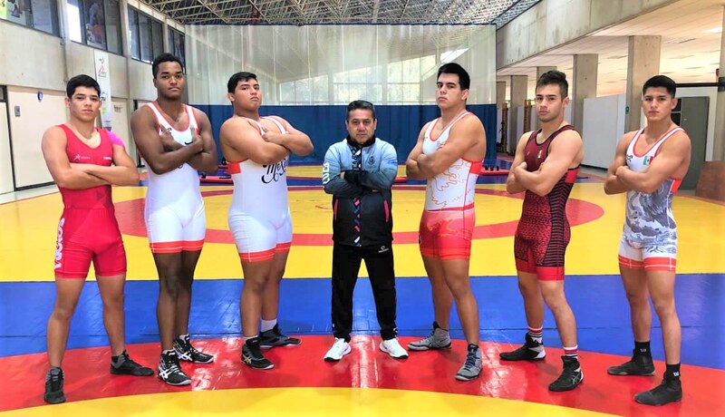 Luchadores mexicanos posan con su entrenador