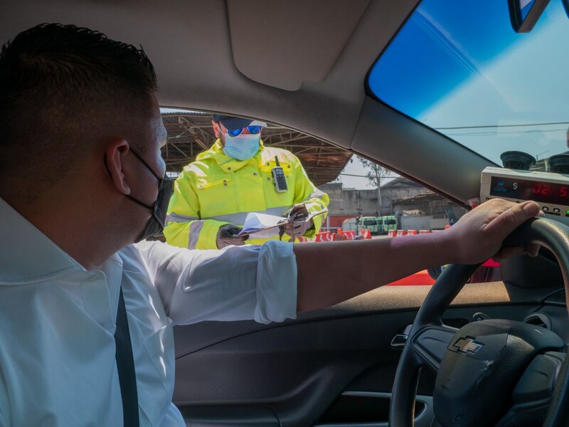 Un policía de tránsito multa a un conductor en una calle de la ciudad.