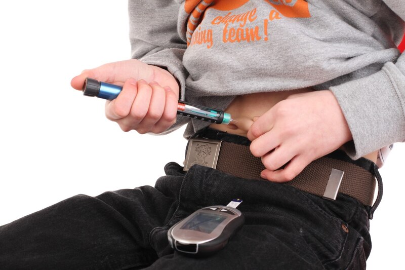 Niño con diabetes se inyecta insulina