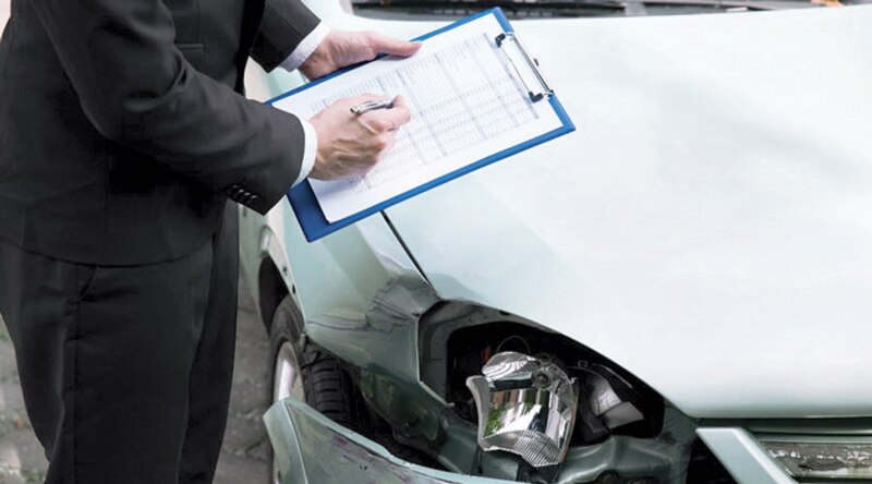 Perito de seguros inspecciona los daños de un coche