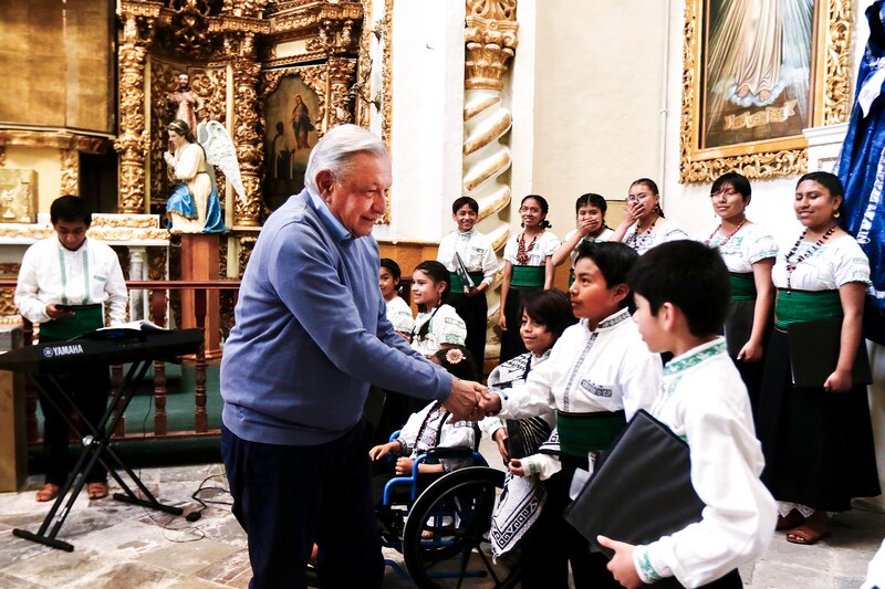 El presidente saluda a los niños de un coro en una iglesia.