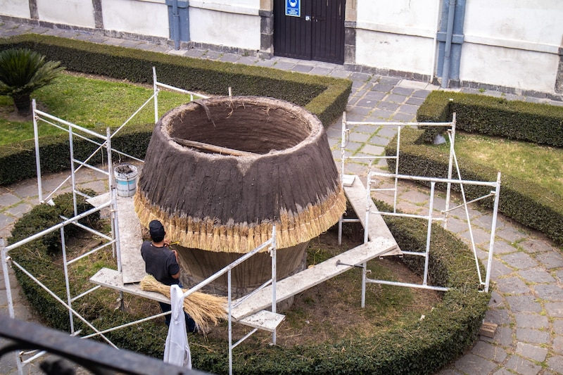 Un hombre construyendo un horno de barro