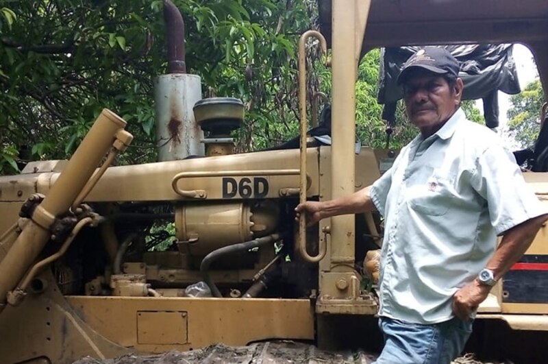Un hombre junto a una excavadora