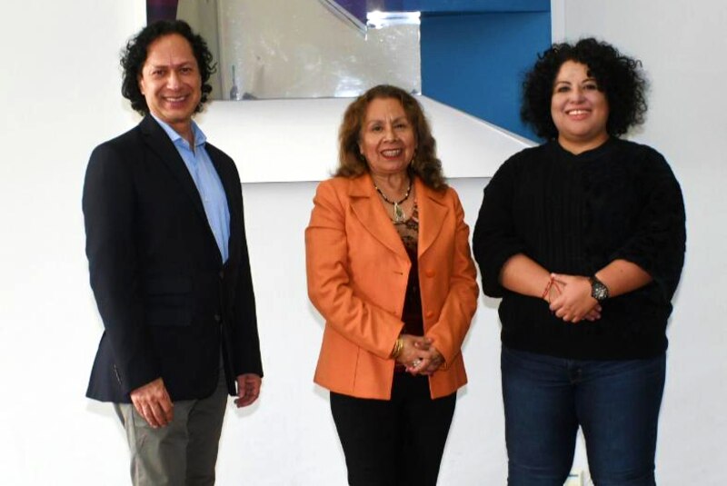 Tres personas sonríen a la cámara.