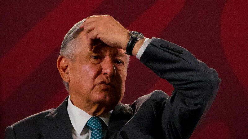El presidente López Obrador se toca la cabeza en un gesto de preocupación.